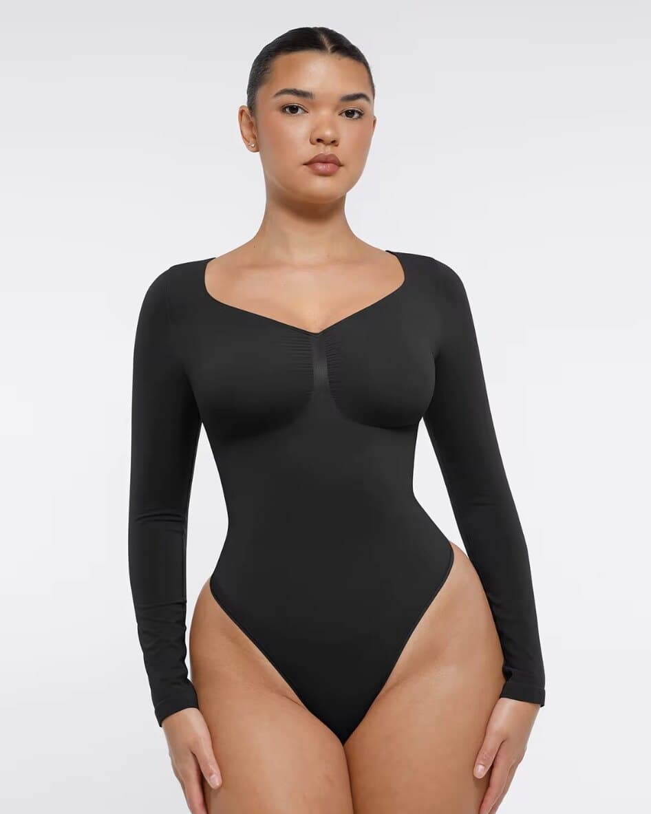 Front view of a model wearing the black IYRA Shape long-sleeve bodysuit.